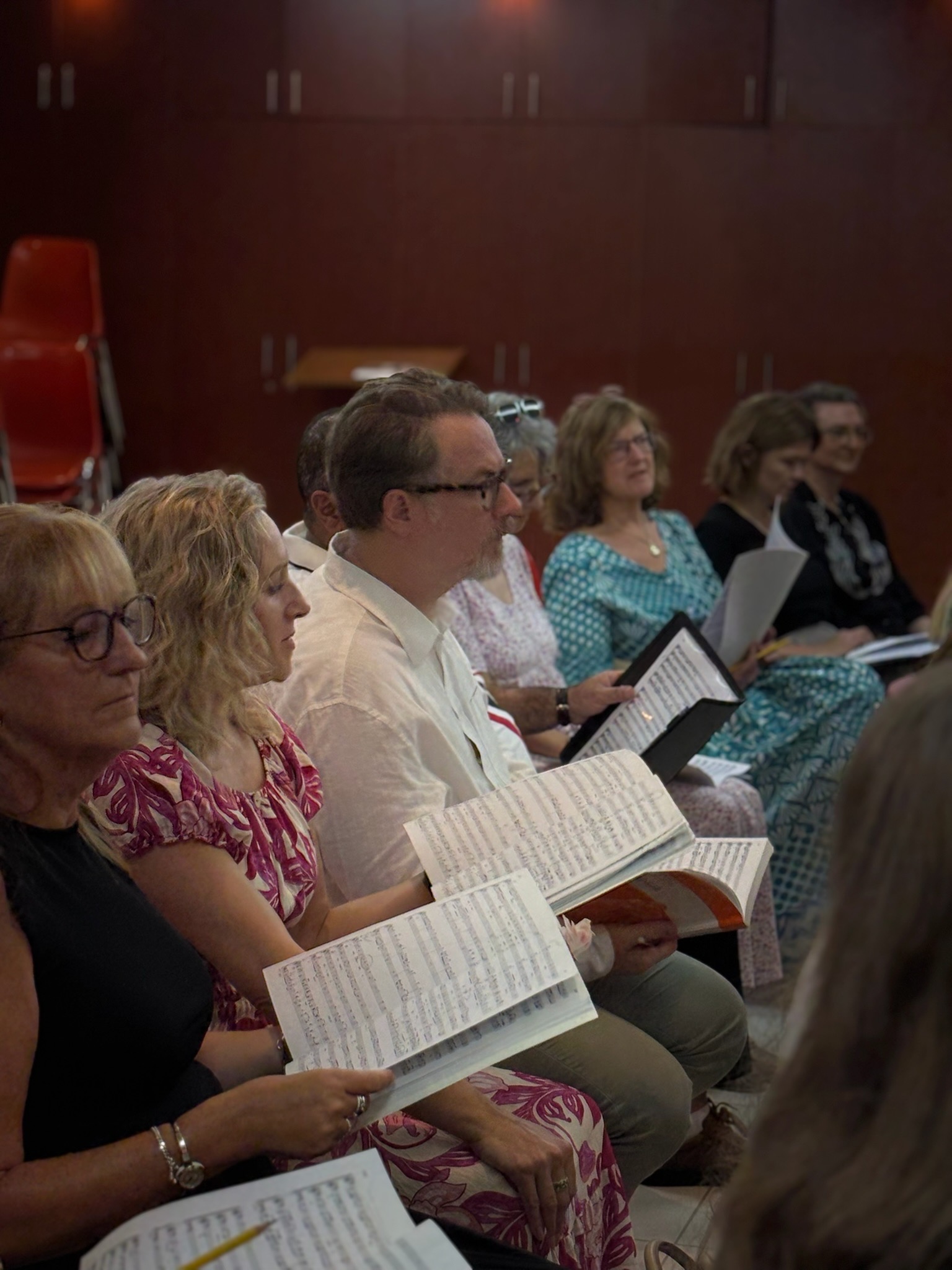 Dubai Singers members reading their scores during rehearsal